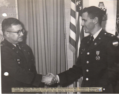 Caption reads: Col. B. Raouls, Ex Off, USAINTS as he congratulates Maj Franklin Schwarz, DCBTI, after presenting him with the Joint Service Commendation Medal, 1964. (Courtesy of Schwarz Family)
