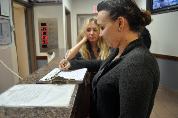 Fordham student signs in her friend at the security desk. (Jessica Hanley/ The Observer)