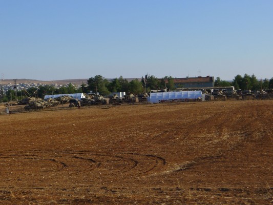 Turkish tanks parked in a lot near the border with Syria on Tuesday, Sept. 30, 2014. The northern Syrian city of Kobani, under siege from Islamic militants, is in the background. (Courtesy Guy Gurman via TNS) 
